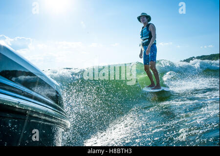 Sorridente senior crociere wakesurfer dietro un Mastercraft wakesurfing barca sul Lago Hartwell in Georgia/South Carolina, Stati Uniti d'America. Foto Stock