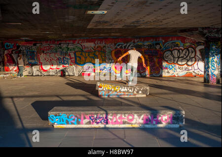 Al guidatore di skateboard skateboard park sotto il teatro nazionale, sul London southbank Foto Stock