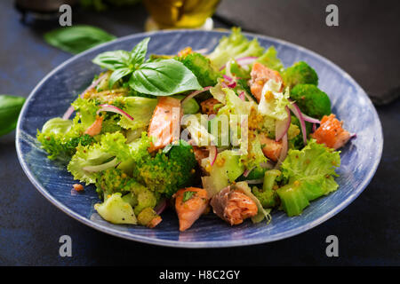 Insalata di pesce stufato di salmone, broccoli, lattuga e condimento. Menu di pesce. Menu dietetici. Frutti di mare - salmone. Foto Stock