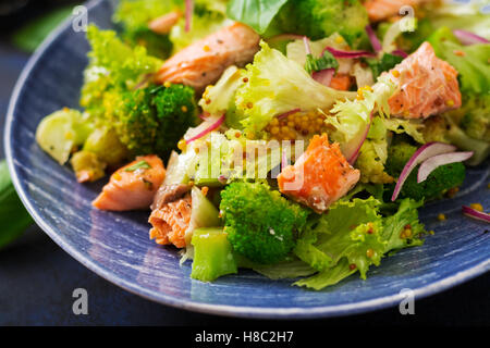 Insalata di pesce stufato di salmone, broccoli, lattuga e condimento. Menu di pesce. Menu dietetici. Frutti di mare - salmone. Foto Stock