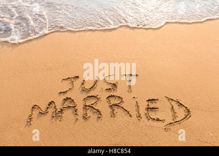 Appena sposato simbolo scritto di sabbia su una spiaggia tropicale - rilassante viaggio luna di miele Foto Stock