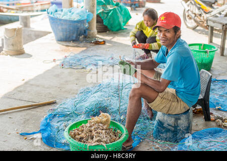 Popolo Thai raccogliere delle catture di frutti di mare dalla rete da pesca in un villaggio a sud di Hua Hin Foto Stock