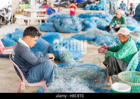 Popolo Thai raccogliere delle catture di frutti di mare dalla rete da pesca in un villaggio a sud di Hua Hin Foto Stock