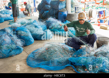 Popolo Thai raccogliere delle catture di frutti di mare dalla rete da pesca in un villaggio a sud di Hua Hin Foto Stock