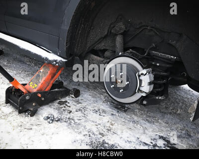 La sostituzione della ruota sul nuovo nero auto SUV, jack mantiene il corpo in posizione sollevata Foto Stock