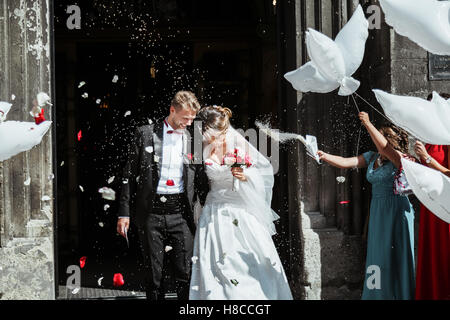 Sposa e lo sposo che va al di fuori della chiesa Foto Stock