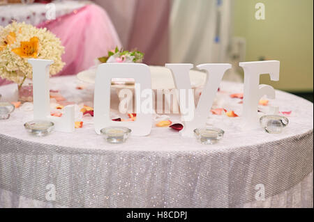 Bianco in legno lettere amore sul tavolo. Decorazioni per matrimoni Foto Stock