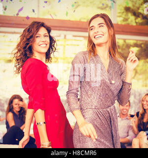 Immagine composita di donne che danzano e gruppo di amici a guardare la loro danza Foto Stock