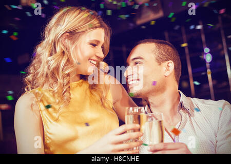 Immagine composita della giovane la tostatura con champagne Foto Stock