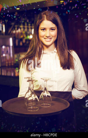 Immagine composita del ritratto di cameriera tenendo il vassoio con bicchieri di vino Foto Stock