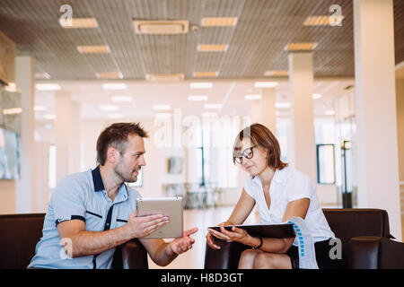 Due colleghi per discutere idee di business seduti sulle sedie in ufficio Foto Stock