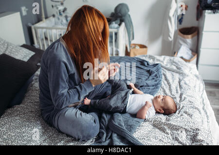 Madre con il suo bambino in camera da letto Foto Stock