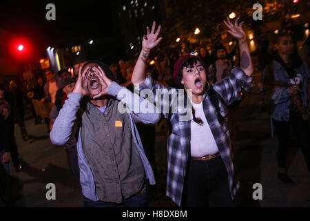 Oakland, la California, Stati Uniti d'America. Xi Nov, 2016. NEKEIA RIDEOUT (sinistra) e ciliegia boga (destra) gridare come essi marzo durante una manifestazione di protesta pacifica contro il Presidente eletto Donald Trump a Oakland, in California. Credito: Joel Angelo Ju''¡Rez/ZUMA filo/Alamy Live News Foto Stock