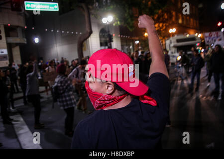 Oakland, la California, Stati Uniti d'America. Xi Nov, 2016. Un protestor indossando un Hillary Clinton hat solleva il pugno durante una manifestazione di protesta pacifica contro il Presidente eletto Donald Trump a Oakland, in California. Credito: Joel Angelo Ju''¡Rez/ZUMA filo/Alamy Live News Foto Stock