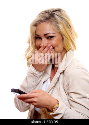 Una donna è ridere mentre si tiene il suo telefono cellulare. Foto Stock