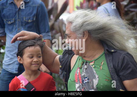 Uomo malese che accarezzano il suo nipote dopo la riproduzione di musica per le strade di Kuala Lumpur in Malesia Foto Stock