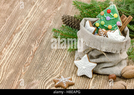 Natale regalo piccola borsa con fatti in casa di panpepato cookie e i dadi su sfondo di legno Foto Stock