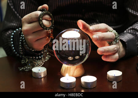 Stregone con le mani su un cristallo trasparente fortune ball-dicono per il futuro Foto Stock