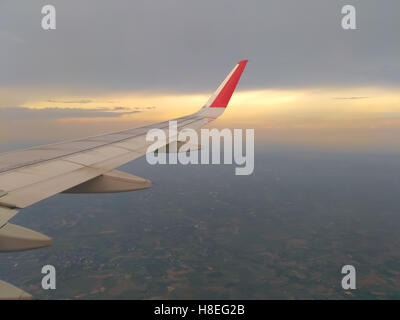 Vista da finestra aereo prima di atterrare al tramonto Foto Stock