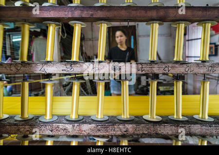 Un tessitore di seta crea un bullone di filo d'oro presso un laboratorio tradizionale a Bangkok, Thailandia, Sud-est asiatico, in Asia Foto Stock