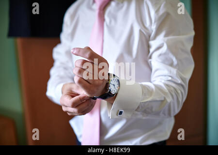 Lo sposo indossa un orologio per la mano Foto Stock