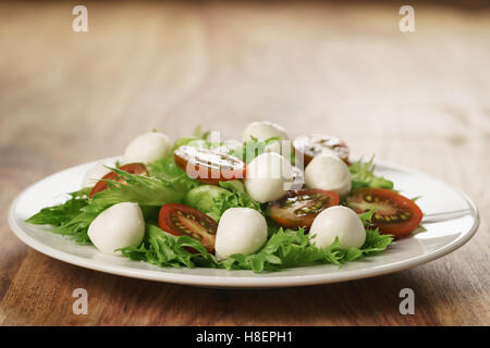 Insalata con kumato pomodoro, mozzarella e lattuga frillies Foto Stock