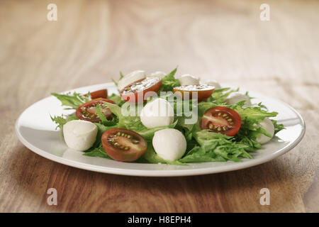 Insalata con kumato pomodoro, mozzarella e lattuga frillies Foto Stock