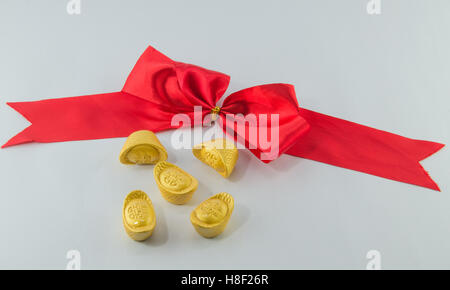 Lingotto oro Red Ribbon bow su sfondo bianco. Foto Stock