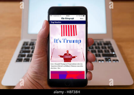 Dettaglio di iPhone smart phone che mostra online giornale mobile anteriore-intestazione della pagina dal telegrafo seguenti Donald Trump's vi Foto Stock