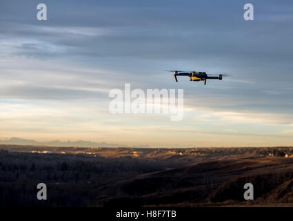 Piccolo e moderno drone passando di scattare una foto del tramonto Foto Stock