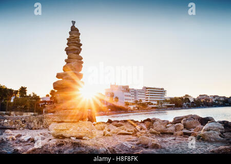 Cairn sul litorale shot nella parte anteriore del sole brillante Foto Stock