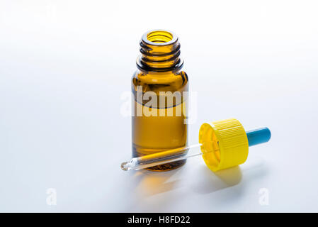 Medicina marrone bottiglia di vetro con contagocce, contagocce, su sfondo grigio Foto Stock