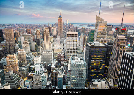 NEW YORK CITY - 3 Settembre 2016: le luci al neon di Times Square competere con una vibrante Sunset over Midtown Manhattan. Foto Stock