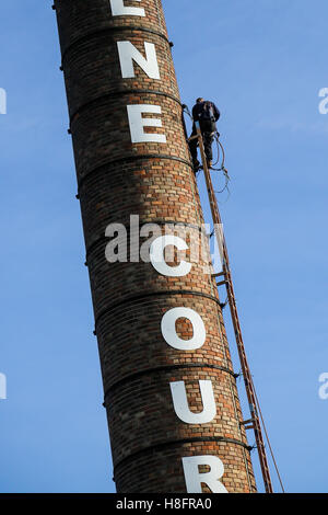 Steeple martinetti lavorando su una molto grande ciminiera in una luminosa giornata di sole Foto Stock