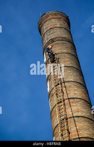 Steeple martinetti lavorando su una molto grande ciminiera in una luminosa giornata di sole Foto Stock