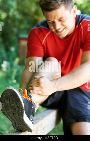 Uomo con sport pregiudizio subito pur esercitando all'aperto Foto Stock