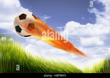 Pallone da calcio sul fuoco e veloci nel cielo. Foto Stock