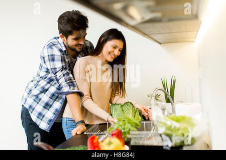 Felice coppia giovane preparare il cibo in cucina Foto Stock