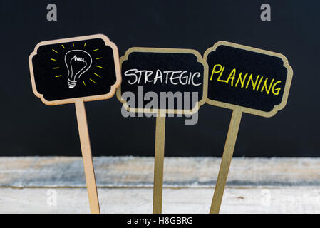 Messaggio di concetto la pianificazione strategica e la lampadina della luce come simbolo per idea scritto con un gessetto su legno mini etichette di Blackboard Foto Stock