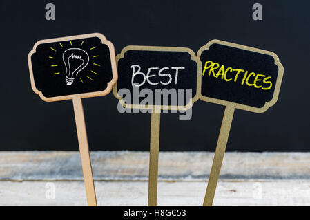 Messaggio di concetto di best practice e lampadina della luce come simbolo per idea scritto con un gessetto su legno mini etichette di Blackboard Foto Stock