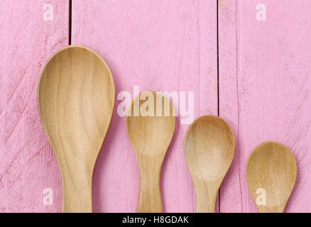 Il cucchiaio di legno sulla rosa dei pavimenti in legno,concetto di stoviglie e utensili di cottura. Foto Stock