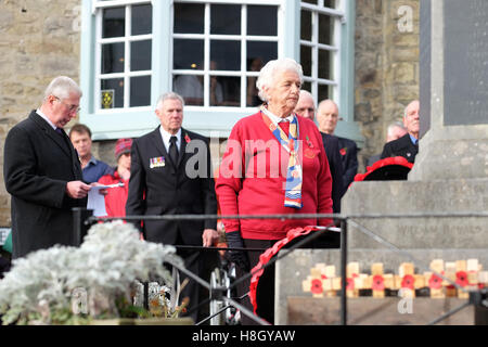 Kington, Herefordshire, Regno Unito - 13 Novembre, 2016. Un rappresentante della gilda di trifoglio pause di riflessione dopo la posa di una corona al Monumento ai caduti in guerra in Kington Herefordshire sul ricordo Domenica. Foto Steven Maggio / Alamy Live News Foto Stock