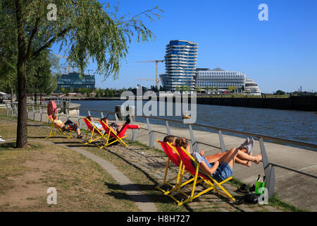 La gente a prendere il sole a Dalmannkai con vista Unileverhaus, Hafencity ad Amburgo in Germania, Europa Foto Stock