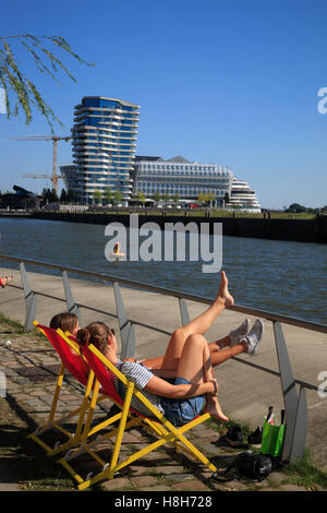 Le donne a prendere il sole a Dalmannkai con vista Unileverhaus, Hafencity ad Amburgo in Germania, Europa Foto Stock