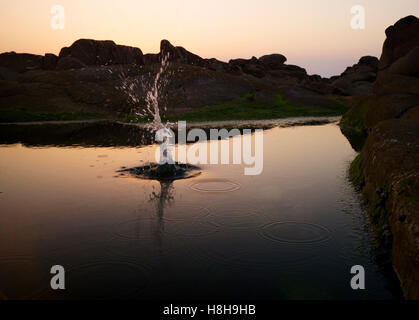 Splash in un rock pool, Ile Grande Bretagna Foto Stock