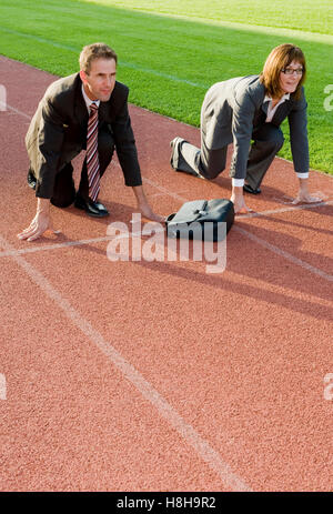 Imprenditore e imprenditrice alla linea di partenza di una via di corsa Foto Stock