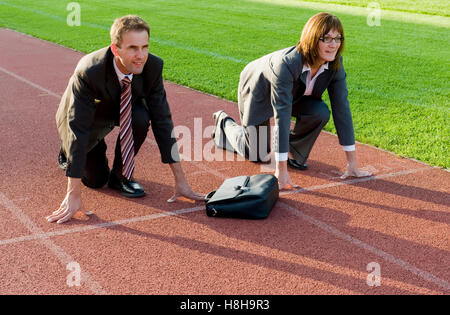 Imprenditore e imprenditrice alla linea di partenza di una via di corsa Foto Stock