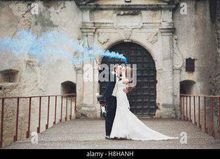 La sposa e lo sposo con fumo bombe sullo sfondo del castello Foto Stock