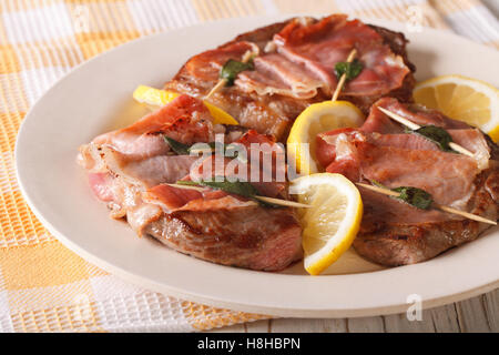 Saltimbocca alla carne bovina con salvia e prosciutto close-up su una piastra orizzontale. Foto Stock