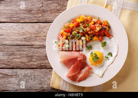 Sana colazione: uovo fritto, jamon e stufato di vegetali su una piastra di close-up. Vista orizzontale dal di sopra Foto Stock